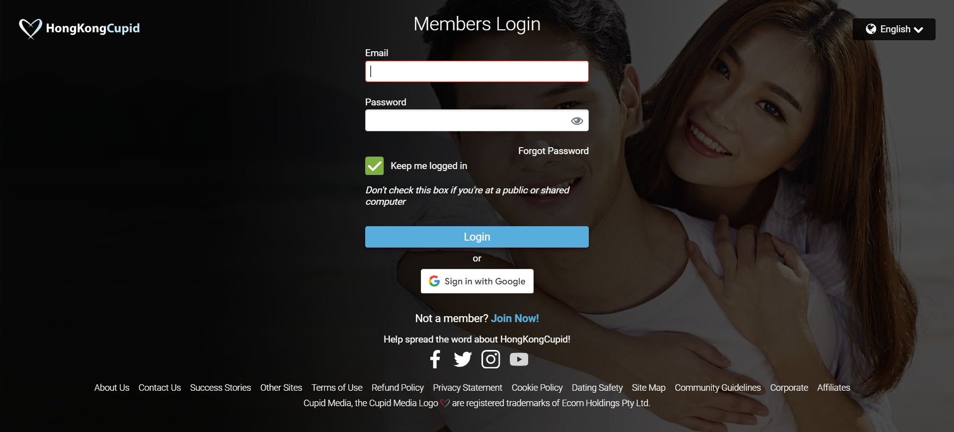A happy couple smiles together in front of a computer screen displaying a login page.